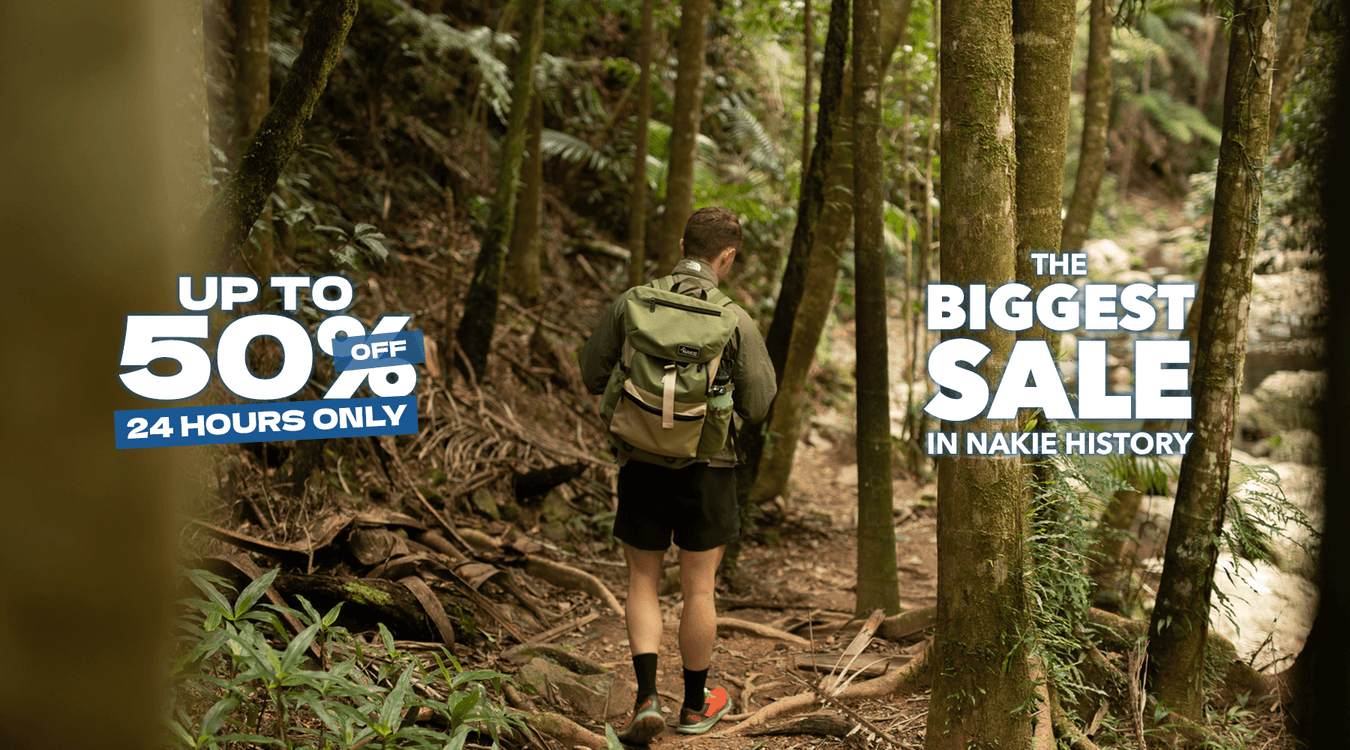 Man hiking in forest with sustainable Nakie backpack made from recycled plastic bottles, ideal eco-friendly hiking gear