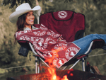 Burgundy recycled beach towel with white circular logo pattern, draped over camping chair by campfire preview #2