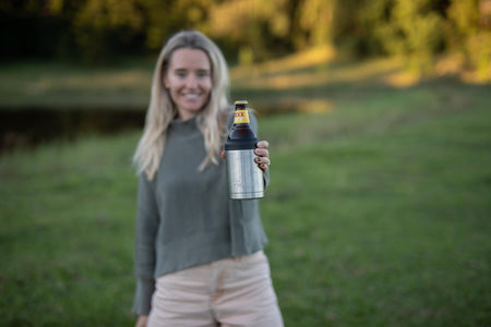 Silver stainless steel bottle cooler holding a beer bottle, displayed outdoors