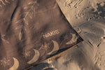 Brown recycled beach towel with gold moon and star pattern, displayed on sand preview #13