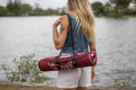 Burgundy recycled picnic blanket with white graphic print, rolled and carried over shoulder with black straps preview #6