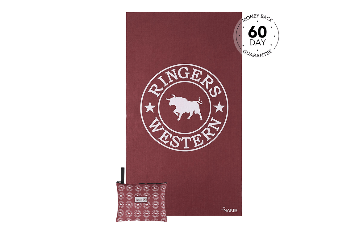 Burgundy beach towel with white bull logo and "Ringers Western" text, displayed with matching patterned carry pouch.