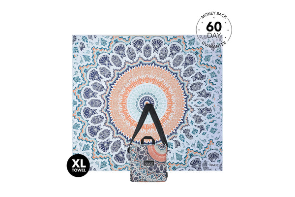 XL beach towel with blue, orange, and cream mandala pattern, shown flat with carrying pouch attached below.