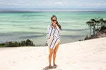 Image of a woman wrapped in Nakie's recycled sand-free beach towel, enjoying comfort and sustainability during her beach outing. preview #9